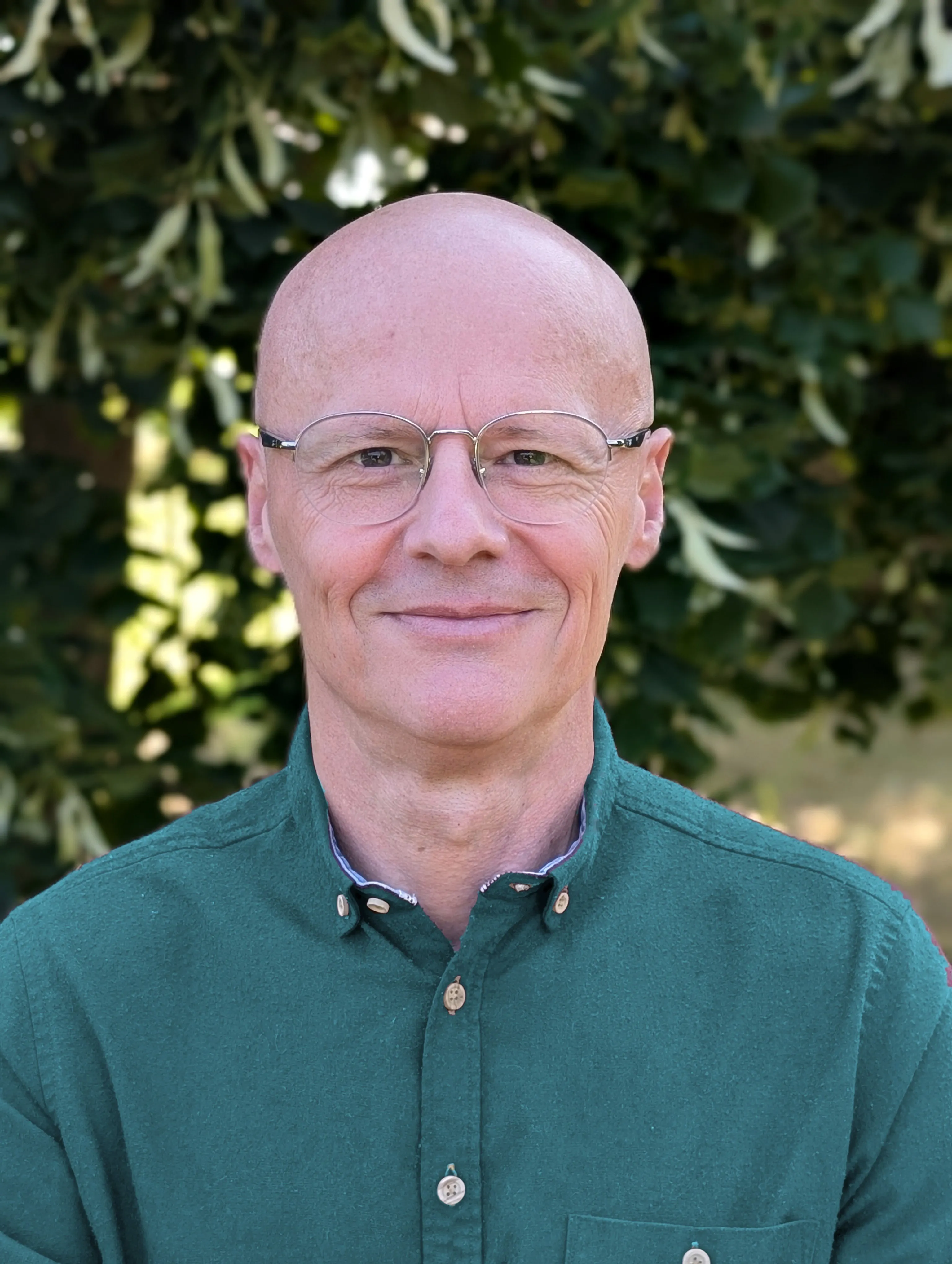 Portrait of Simon Bowen in a petrol-coloured shirt.